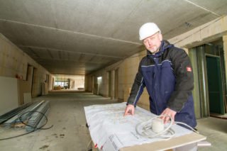 Haustechniker Michael Lüdtke vor den Plänen für das neue Haus St. Martin. Foto: SMMP/Ulrich Bock