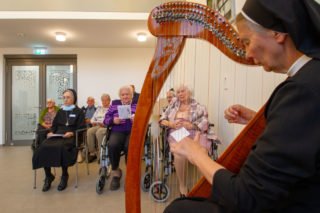 Schwester Theresita Maria Müller aus Beswig spielt zur Kommunion die Harfe. Foto: SMMP/Ulrich Bock
